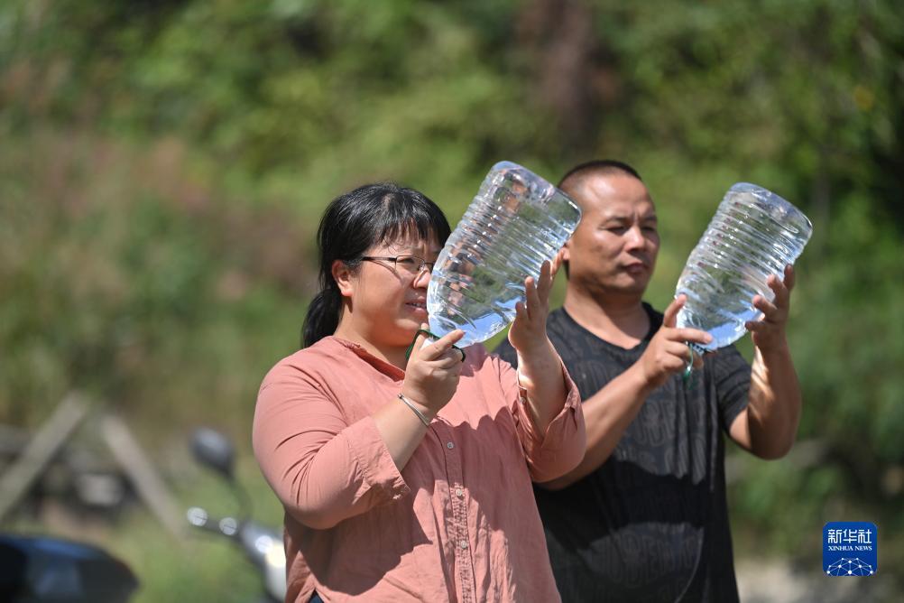 楊寧（左）在查看村民剛剛采集的水樣，為山泉水引水工程做準備（10月8日攝）。新華社記者 黃孝邦 攝